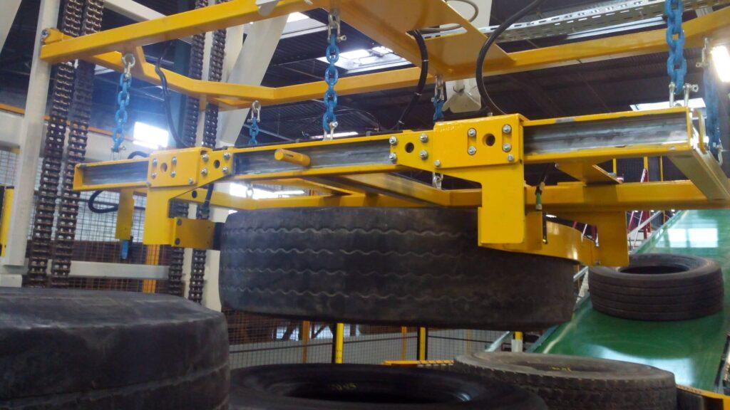 Yellow gantry handling large industrial tyres